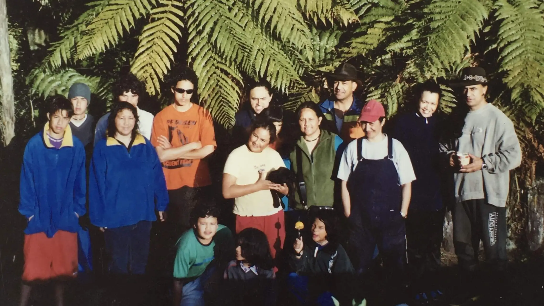 a group of people posing for a photo in front of a palm tree