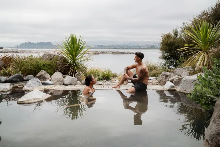 a man and a woman riding a wave on a surfboard in the water