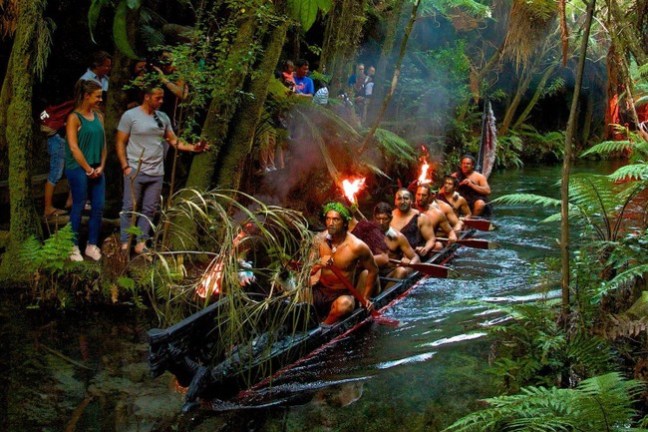 a group of people standing next to a waterfall